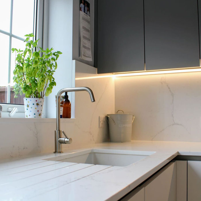 Eat-in kitchen - large modern l-shaped vinyl floor and gray floor eat-in kitchen idea in Other with a drop-in sink, flat-panel cabinets, quartzite countertops, white backsplash, quartz backsplash, bla