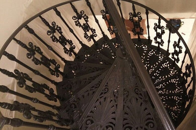 Ejemplo de escalera de caracol minimalista de tamaño medio con escalones de metal, contrahuellas de metal y barandilla de metal