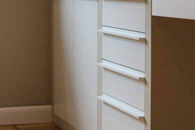 Badezimmer mit flächenbündigen Schrankfronten, weißen Schränken, grauer Wandfarbe, hellem Holzboden, Trogwaschbecken und Mineralwerkstoff-Waschtisch in Sonstige