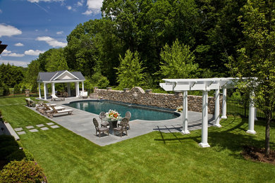 Photo of a large traditional full sun backyard concrete paver retaining wall landscape in Boston.