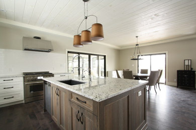 Mid-sized transitional u-shaped dark wood floor and brown floor open concept kitchen photo in Toronto with an undermount sink, shaker cabinets, white cabinets, granite countertops, white backsplash, subway tile backsplash, stainless steel appliances and an island