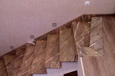 Источник вдохновения для домашнего уюта: изогнутая лестница среднего размера с мраморными ступенями и подступенками из мрамора
