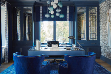 Ejemplo de estudio clásico renovado grande con paredes azules, suelo de madera clara, escritorio independiente, suelo beige, papel pintado y papel pintado