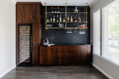 Small mid-century modern single-wall dry bar photo in Dallas with no sink, flat-panel cabinets, dark wood cabinets, quartz countertops, black backsplash, stone slab backsplash and black countertops