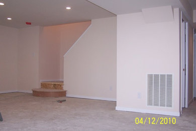 Basement - huge modern walk-out carpeted basement idea in Columbus with beige walls