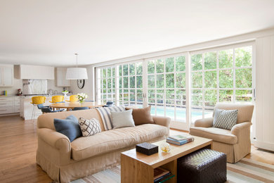 Family room - large coastal open concept medium tone wood floor family room idea in Los Angeles with white walls