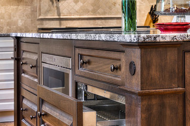 Kitchen pantry - large traditional u-shaped light wood floor kitchen pantry idea in Other with a farmhouse sink, raised-panel cabinets, beige cabinets, granite countertops, beige backsplash, stone tile backsplash, stainless steel appliances and an island