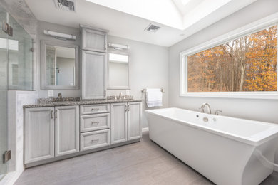 Inspiration for a large modern master gray tile double-sink bathroom remodel in New York with gray cabinets, an undermount sink, a hinged shower door and multicolored countertops