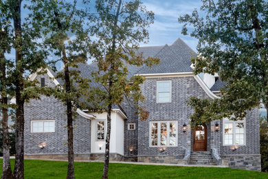 Large french country gray two-story mixed siding house exterior idea in Little Rock with a hip roof and a shingle roof