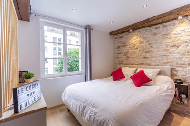 リヨンにある中くらいなトランジショナルスタイルのおしゃれな主寝室 (ベージュの壁、淡色無垢フローリング、暖炉なし、ベージュの床、レンガ壁) のインテリア