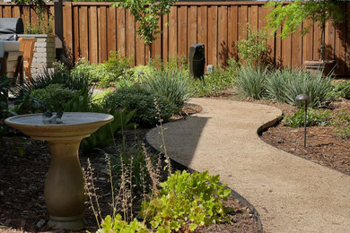 Diseño de jardín tradicional de tamaño medio en patio trasero con exposición parcial al sol, fuente y granito descompuesto