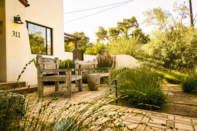 Inspiration for a mediterranean drought-tolerant front yard landscaping in Other with a pergola.
