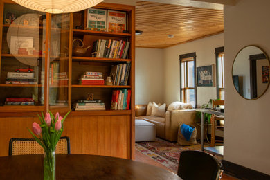 Example of a mid-sized eclectic loft-style living room library design in Other with white walls and a corner tv