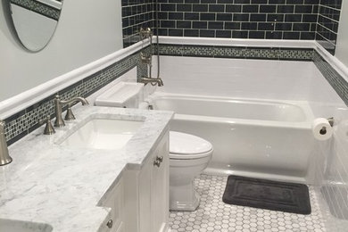 Inspiration for a mid-sized transitional kids bathroom in New York with beaded inset cabinets, white cabinets, marble benchtops, an alcove tub, a two-piece toilet, white tile, subway tile, grey walls and marble floors.