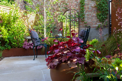 Esempio di un piccolo giardino minimal esposto a mezz'ombra in cortile in estate con pavimentazioni in pietra naturale e recinzione in legno