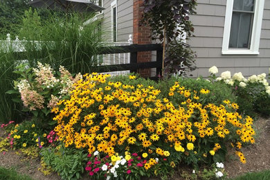 Design ideas for a mid-sized farmhouse full sun landscaping in Columbus for summer.