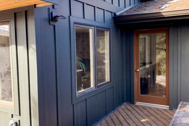 Foto de fachada de casa gris minimalista con revestimiento de aglomerado de cemento y panel y listón