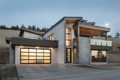 Large contemporary gray two-story stucco exterior home idea in Vancouver