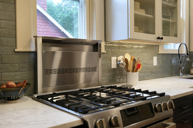 Mid-sized arts and crafts galley medium tone wood floor and brown floor enclosed kitchen photo in Baltimore with an undermount sink, shaker cabinets, blue cabinets, quartz countertops, green backsplash, ceramic backsplash, stainless steel appliances, no island and white countertops