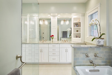 Inspiration for a traditional bathroom in Chicago with raised-panel cabinets, white cabinets, a drop-in tub, a corner shower, a one-piece toilet, blue tile, subway tile, blue walls, porcelain floors, an undermount sink, quartzite benchtops and a hinged shower door.