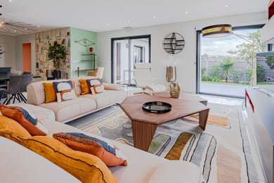 Imagen de sala de estar abierta moderna grande sin chimenea con paredes verdes, suelo de baldosas de cerámica, televisor independiente, suelo beige y papel pintado
