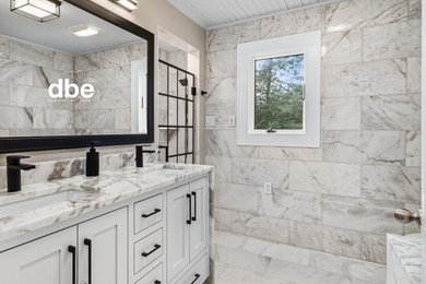 Example of a large white tile and marble tile marble floor, white floor and double-sink walk-in shower design in Other with flat-panel cabinets, white cabinets, an undermount tub, a two-piece toilet, beige walls, an undermount sink, marble countertops, a hinged shower door, white countertops and a built-in vanity