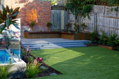 Diseño de jardín contemporáneo de tamaño medio en patio trasero con macetero elevado, exposición total al sol y adoquines de piedra natural