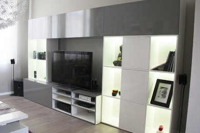 Diseño de sala de estar abierta actual grande con paredes grises, suelo laminado, televisor independiente y suelo gris