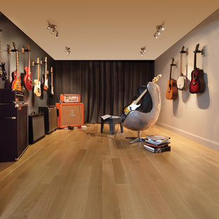 Immagine di un soggiorno moderno di medie dimensioni e aperto con sala della musica, parquet chiaro e pareti grigie