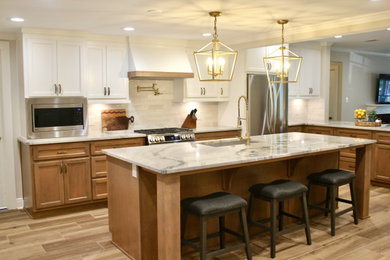 Large beach style l-shaped porcelain tile and brown floor open concept kitchen photo in Other with a single-bowl sink, shaker cabinets, medium tone wood cabinets, quartzite countertops, beige backsplash, ceramic backsplash, stainless steel appliances, an island and gray countertops