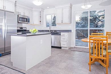 Inspiration for a small transitional l-shaped vinyl floor and gray floor eat-in kitchen remodel in Other with quartz countertops, stainless steel appliances, a double-bowl sink, recessed-panel cabinets, white cabinets, gray backsplash and an island