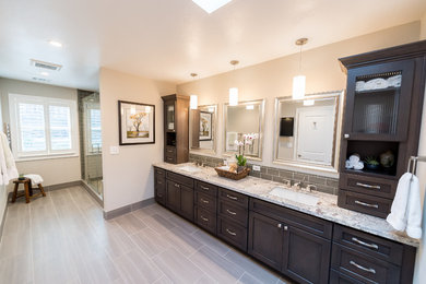 Large transitional master green tile and glass tile porcelain tile alcove shower photo in San Francisco with recessed-panel cabinets, dark wood cabinets, a two-piece toilet, beige walls, a drop-in sink and granite countertops