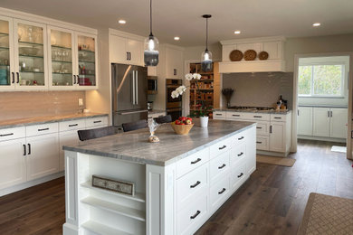 Inspiration for a large transitional u-shaped dark wood floor and brown floor open concept kitchen remodel in San Luis Obispo with a farmhouse sink, shaker cabinets, white cabinets, quartzite countertops, gray backsplash, glass tile backsplash, stainless steel appliances, an island and multicolored countertops