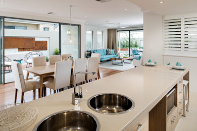 Inspiration for a contemporary u-shaped eat-in kitchen in Perth with a double-bowl sink, flat-panel cabinets, light wood cabinets, granite benchtops, glass sheet splashback, stainless steel appliances, medium hardwood floors and a peninsula.