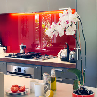 Mid-sized contemporary kitchen pantry ideas - Example of a mid-sized trendy kitchen pantry design in Wellington with gray cabinets, glass sheet backsplash and stainless steel appliances