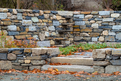 Photo of a large farmhouse backyard stone retaining wall landscape in Boston.