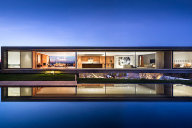Pool - contemporary backyard rectangular infinity pool idea in New York