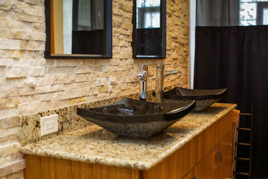 Inspiration for a mid-sized zen master beige tile and stone slab travertine floor bathroom remodel in Chicago with a vessel sink, medium tone wood cabinets, granite countertops, a one-piece toilet and beige walls