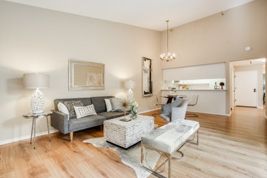 Living room - small eclectic formal and open concept laminate floor, brown floor and vaulted ceiling living room idea in San Francisco with beige walls, no fireplace and no tv