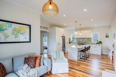 Kleines, Offenes Klassisches Wohnzimmer mit weißer Wandfarbe, braunem Holzboden und Holzdielenwänden in Auckland