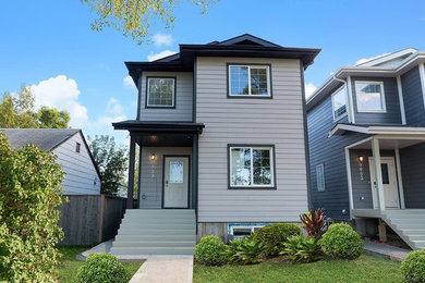 Inspiration for a mid-sized transitional gray two-story wood exterior home remodel in Edmonton with a clipped gable roof