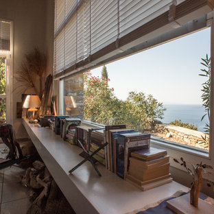 Mediterranes Wohnzimmer im Loft-Stil mit Hängekamin, Kaminsims aus Backstein, grauer Wandfarbe und Keramikboden in Sonstige