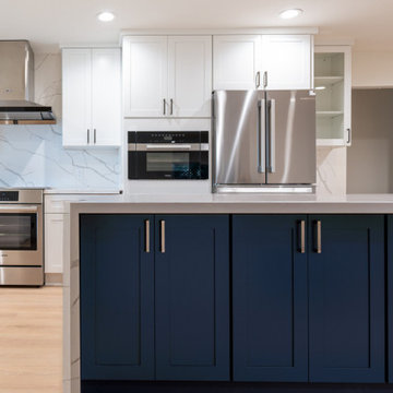Modern White Shaker Kitchen with Navy Blue Island and Waterfall Quartz Counterto