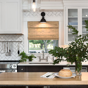 Mid-sized farmhouse open concept kitchen remodeling - Example of a mid-sized farmhouse single-wall light wood floor and brown floor open concept kitchen design in Other with an undermount sink, beaded inset cabinets, white cabinets, quartz countertops, white backsplash, subway tile backsplash, stainless steel appliances and an island