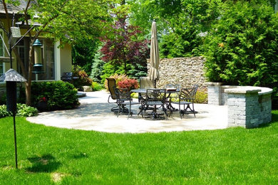 Patio - mid-sized traditional backyard stone patio idea in Toronto with a fire pit and a pergola