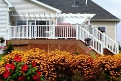 Example of a backyard deck design in Boston with an awning