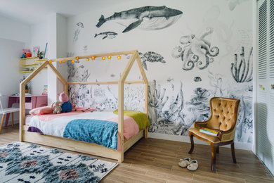 Modelo de dormitorio infantil de 1 a 3 años ecléctico de tamaño medio con paredes blancas, suelo de baldosas de cerámica, suelo marrón y papel pintado