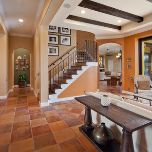 Inspiration for a large mediterranean formal open plan living room in Orlando with orange walls, terracotta flooring, a standard fireplace, a tiled fireplace surround and no tv.