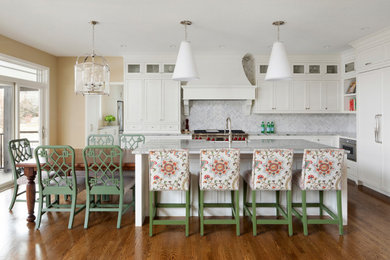 Mid-sized transitional l-shaped light wood floor and brown floor open concept kitchen photo with marble countertops, ceramic backsplash, white appliances, an island, gray countertops, a farmhouse sink and white backsplash