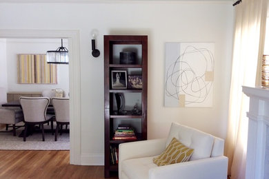 Example of a mid-sized minimalist open concept light wood floor living room design in Los Angeles with white walls, a standard fireplace and no tv